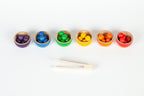 Colourful wooden toy bowls and colourful marbles with a pair of wooden tweezers 