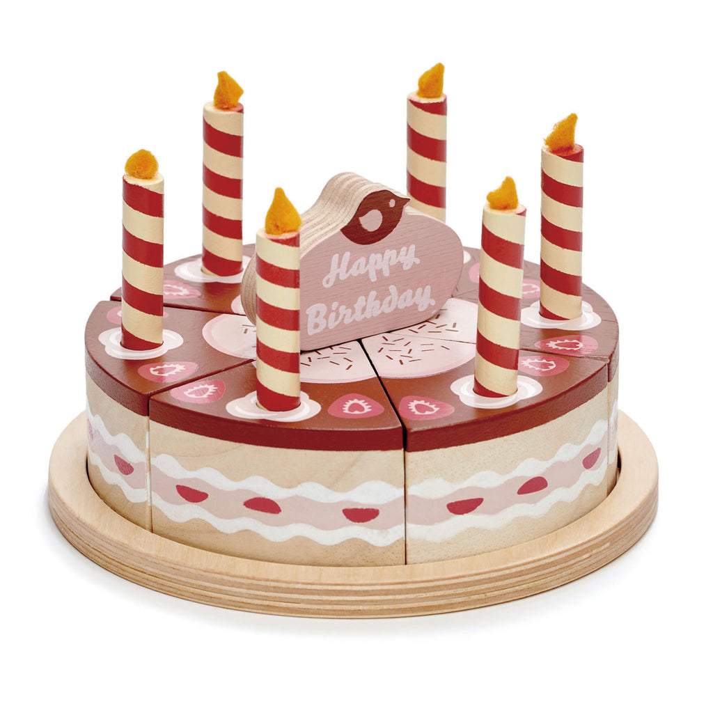 Wooden toy chocolate birthday cake with six candles and cake topper which says happy birthday.  The cake is divided into six pieces and presented on a wooden plate.