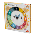 Side view of box containing wooden bear clock with removable numbers and moving hands.