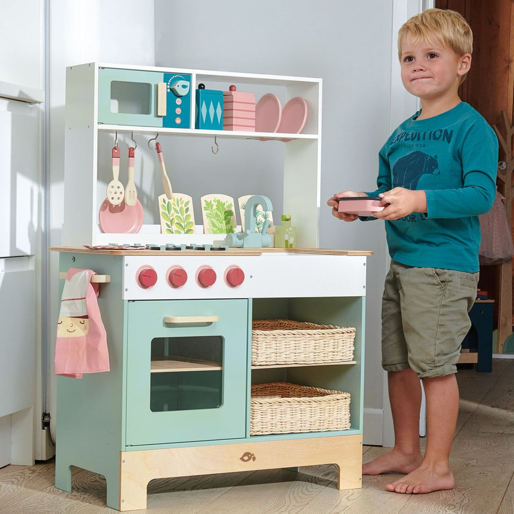 Tender Leaf Toys Kitchen Range front view with child showing kitchen accessories 