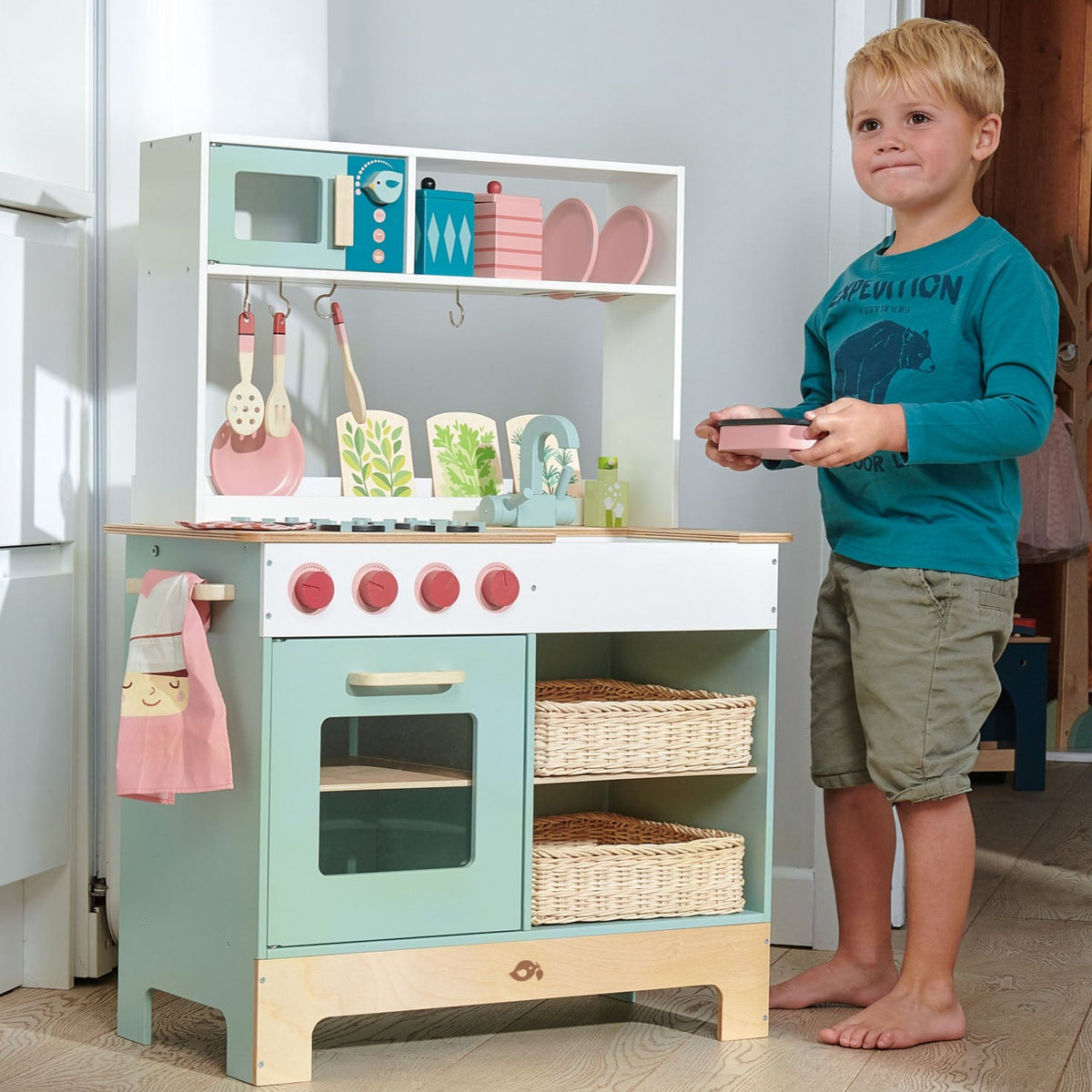 Tender Leaf Toys Kitchen Range front view with child showing kitchen accessories 